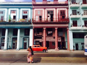 Woman walking on street by building