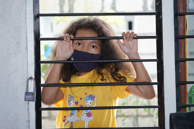 Portrait of girl standing by window