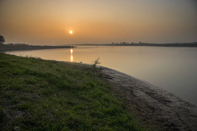 Scenic view of lake against sky during sunset