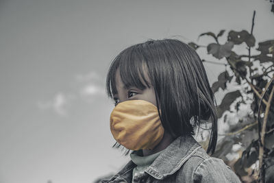 Portrait of girl looking at camera against sky