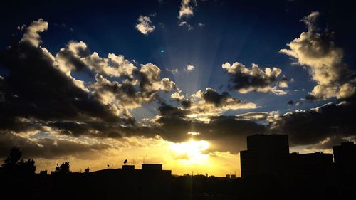 Silhouette cityscape against sky during sunset