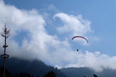 Low angle view of people paragliding