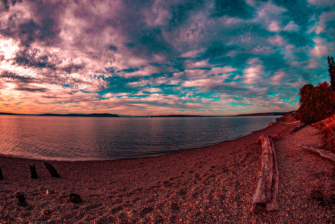 SCENIC VIEW OF BEACH AGAINST DRAMATIC SKY