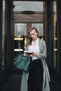 Woman looking at camera while standing on mirror