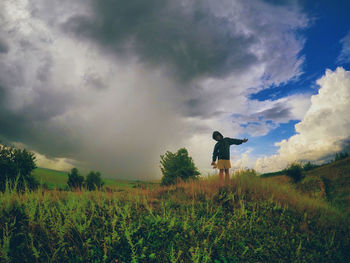 Man standing on field against sky