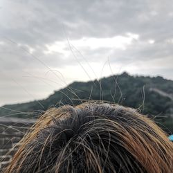 Close-up of hair against sky