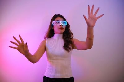 Portrait of young woman wearing sunglasses standing against sky