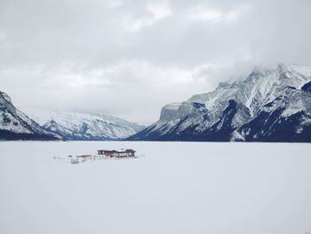 Scenic view of lake by mountains against sky