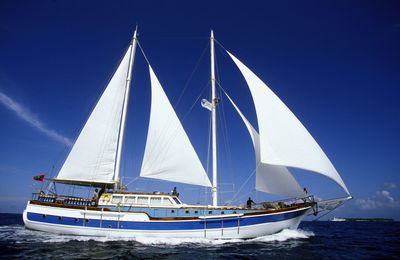 Yacht in sea against blue sky