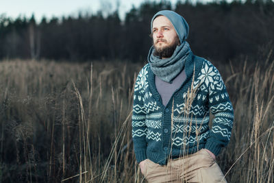 Portrait of man standing in field during winter