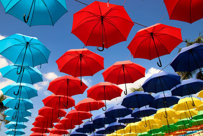 Low angle view of multi colored umbrellas against sky