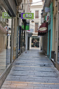 Footpath amidst buildings in city