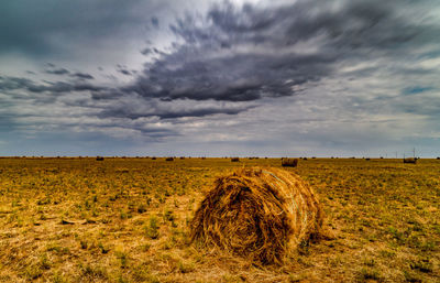 Hay bales on field against sky