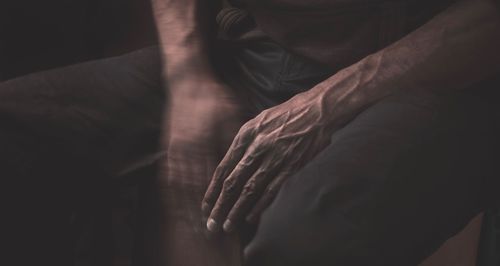 Midsection of man shaking hand in darkroom