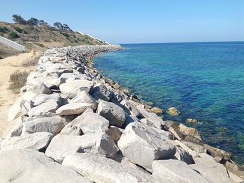 Scenic view of rocks in sea against sky