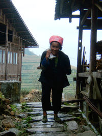 Young woman standing by railing