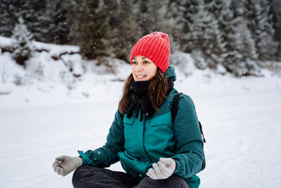Portrait of smiling woman skiing on snow covered field