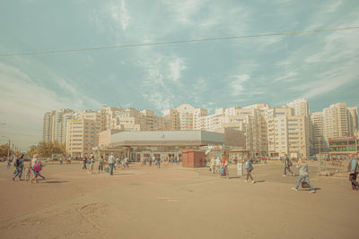 People on beach against buildings in city