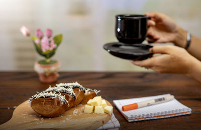 Close-up of hand holding drink served on table