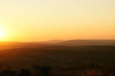 Scenic view of field against sky during sunset