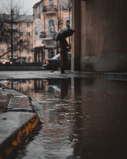 Reflection of buildings on wet street in rainy season