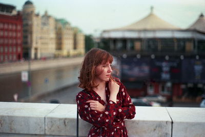 Young woman standing against built structure