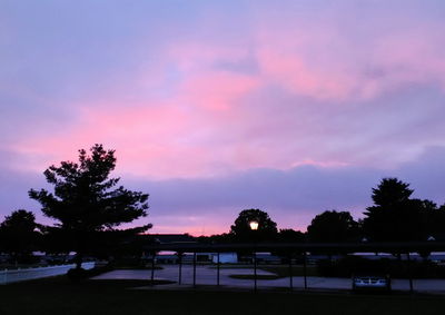 Silhouette trees against dramatic sky during sunset