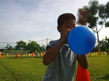 Boy playing with ball in park