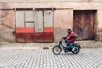 Side view of boy riding bicycle on street