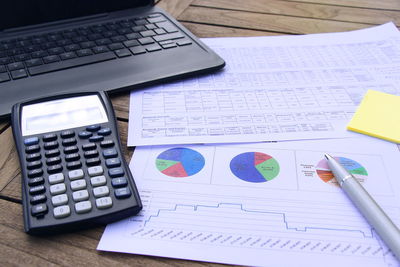 Close-up of documents with calculator at desk in office