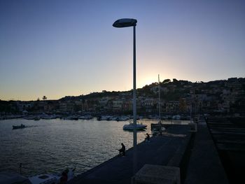 Street by buildings against clear sky at sunset