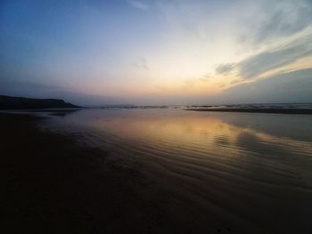 Scenic view of beach against sky during sunset