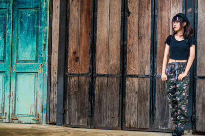 Portrait of woman standing against closed door