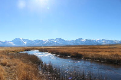 Scenic view of lake and mountains against blue sky