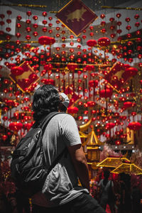 Rear view of man standing watching chinese lanterns