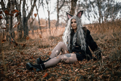 Young woman standing against tree during autumn