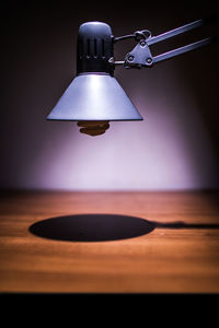 Close-up of electric lamp hanging on table