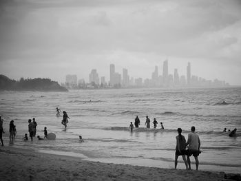 People at beach against sky