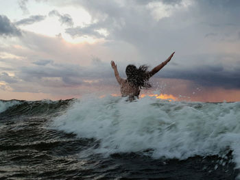 Man surfing in sea against sky