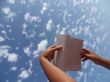 Low angle view of cropped hand against clear sky