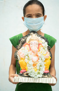 Close-up portrait of a girl holding flower