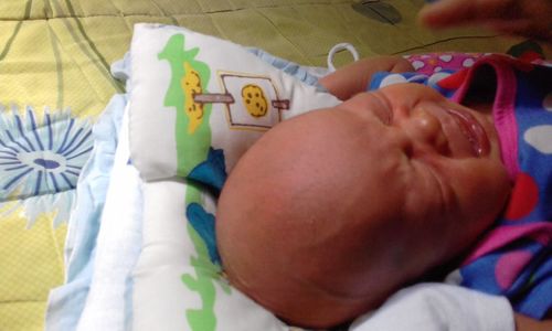 Close-up of baby sleeping in bed