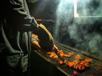 Close-up of person preparing food on barbecue grill