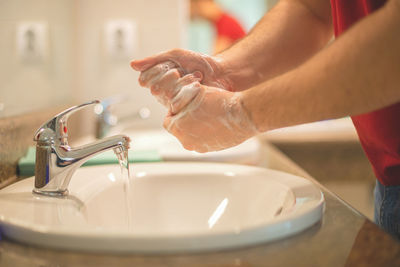 Midsection of woman in bathroom at home