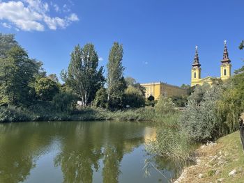 Scenic view of lake by buildings against sky