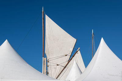 Low angle view of sailing ship masts against clear blue sky