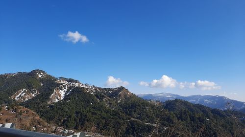 Scenic view of mountains against blue sky