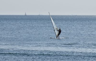 Man surfing in sea against sky