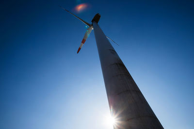 Low angle view of windmill against blue sky