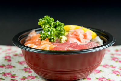Close-up of chirashi in bowl on table against black background